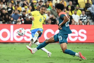 Raphinha controlando el balón con el dorsal 10 de la selección de Brasil frente a un defensor de Australia.