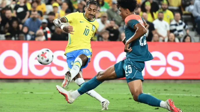 Raphinha controlando el balón con el dorsal 10 de la selección de Brasil frente a un defensor de Australia.