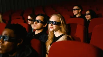 Espectadores en el interior de una sala de cine oscura usando gafas 3D para ver una película