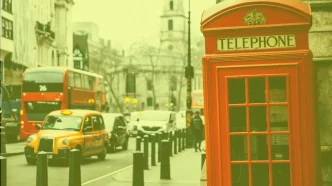 Icónica cabina telefónica roja británica y un taxi amarillo en una calle de Londres bajo un tono cálido y soleado.