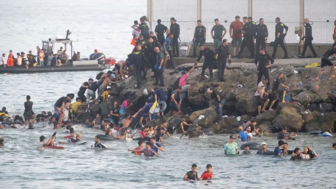 Agentes de las Fuerzas de Seguridad gestionando la llegada masiva de personas en el espigón fronterizo de Ceuta.