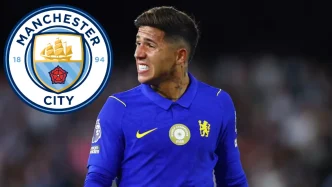 El centrocampista Enzo Fernández luciendo la equipación azul junto al escudo oficial del Manchester City