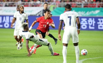 Jugador de la selección de Corea del Sur disputando el balón frente a defensores de la selección de Ecuador durante el amistoso en Suwon.