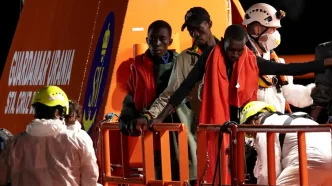 Equipos de rescate marítimo auxiliando a migrantes supervivientes en la cubierta de una embarcación en Canarias
