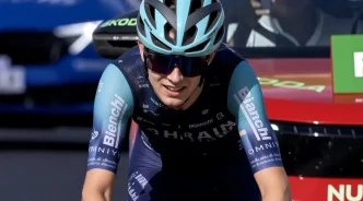 Ciclista con equipación y casco de ciclismo sonriendo tras una etapa