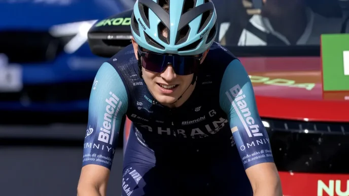 Ciclista con equipación y casco de ciclismo sonriendo tras una etapa