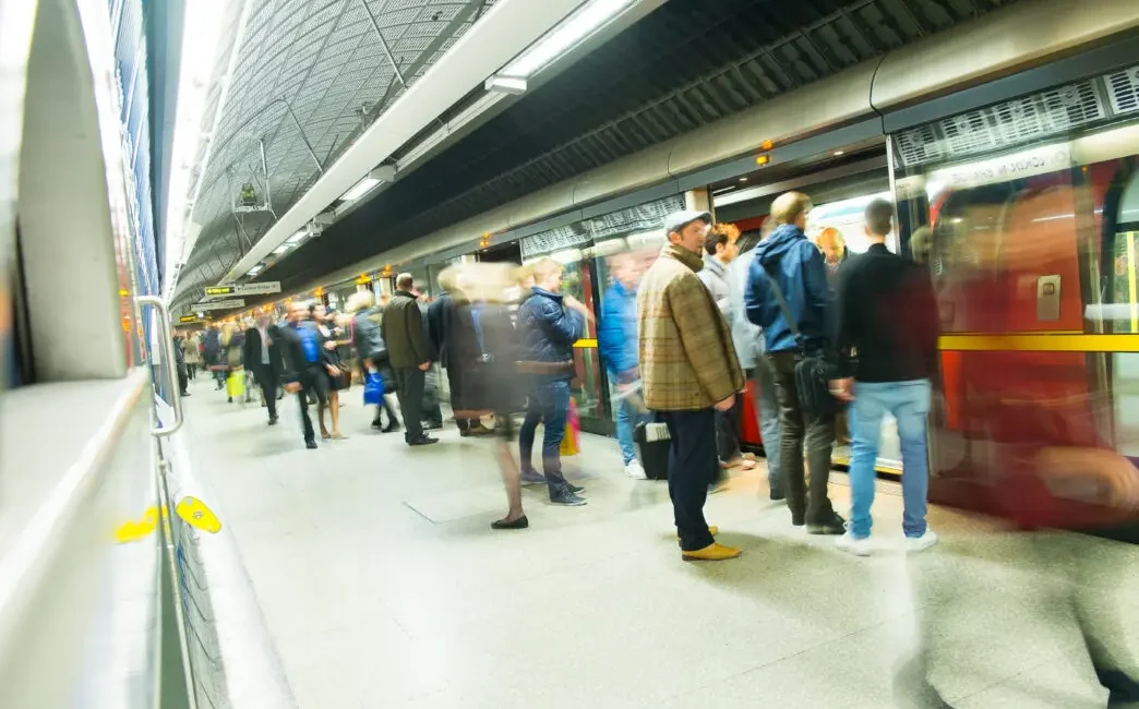 Pasajeros esperando en el andén e ingresando a un vagón del metro de Londres en una estación subterránea.