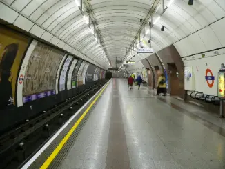 Andén subterráneo del metro de Londres con algunos pasajeros esperando el tren.