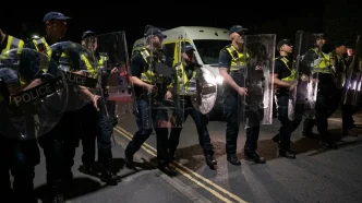 Agentes de policía británicos con escudos antidisturbios desplegados durante la noche en Portsmouth.