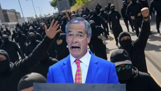 Nigel Farage hablando en primer plano con una multitud de manifestantes enmascarados de negro de fondo.