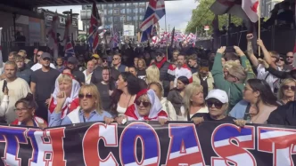 Manifestantes en Portsmouth portando banderas británicas y pancartas durante una protesta sobre migración.