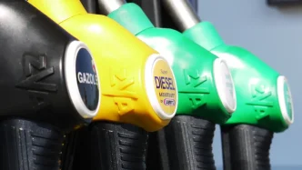 Surtidores de gasolina y diésel de diferentes colores colocados en línea en una estación de servicio.