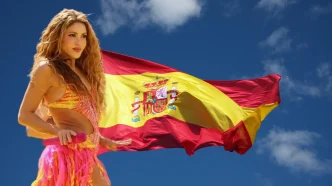 La cantante colombiana Shakira actuando sobre el escenario junto a una gran bandera de España desplegada al fondo.