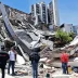 Rescatistas y miembros de los servicios de emergencia frente a un edificio de varios pisos completamente derrumbado tras el terremoto.