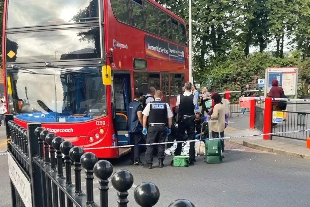 Agentes de policía y servicios de emergencia atendiendo a un peatón en el suelo junto a un autobús rojo de dos pisos acordonado en Walthamstow.