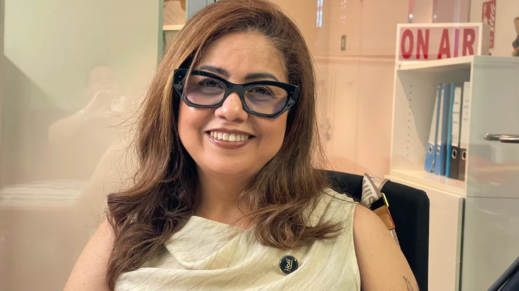 Diana Paola Rincón Gómez, fundadora de Hoff, sonriente con gafas oscuras de pasta y pin corporativo en una oficina.