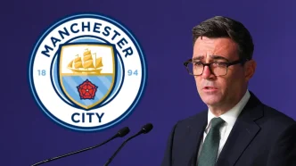 El político Andy Burnham al habla ante unos micrófonos junto al escudo oficial del Manchester City.
