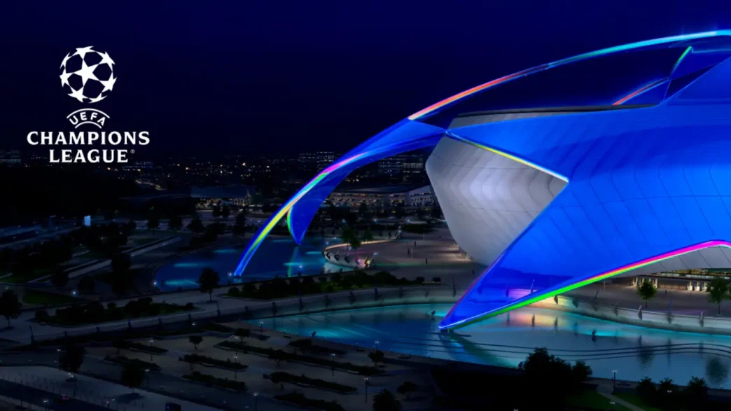 Logo de la UEFA Champions League junto a la estructura de un estadio iluminado de azul en la noche.