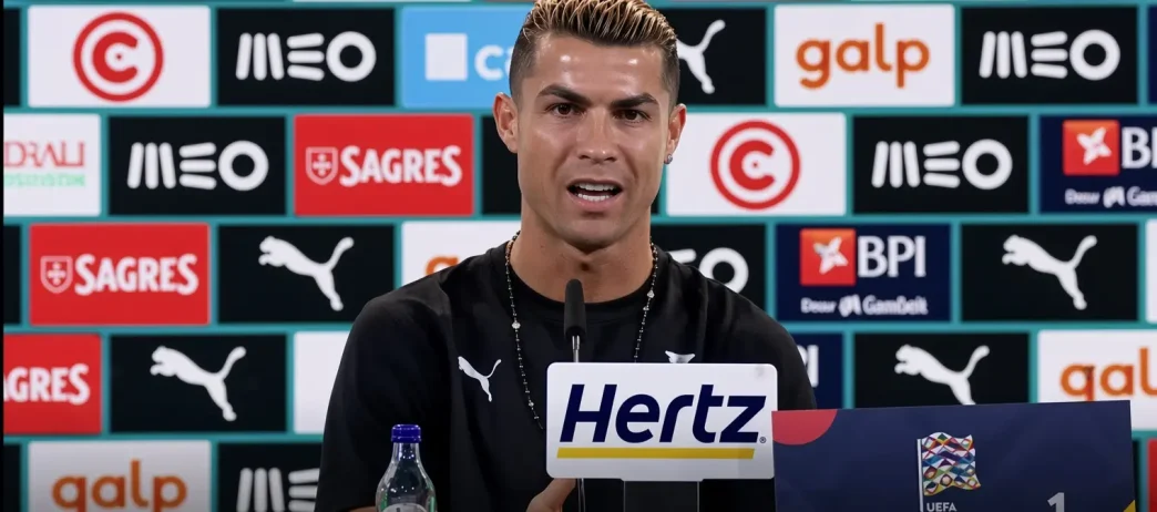 Cristiano Ronaldo en rueda de prensa hablando ante los micrófonos con el panel de patrocinadores de la selección de Portugal de fondo.
