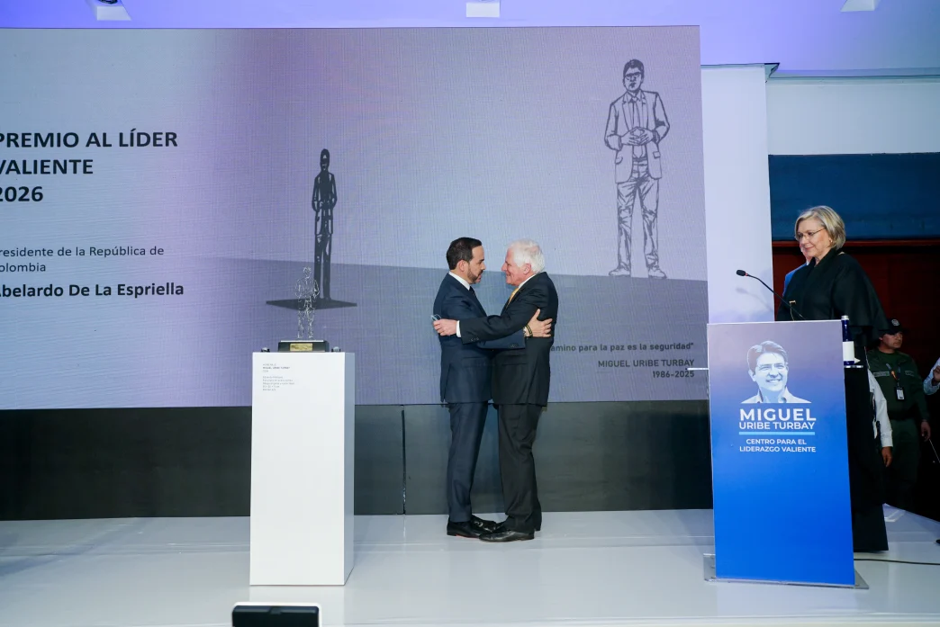 Abelardo de la Espriella recibe un abrazo sobre el escenario tras ser galardonado con el Premio Liderazgo Valiente.