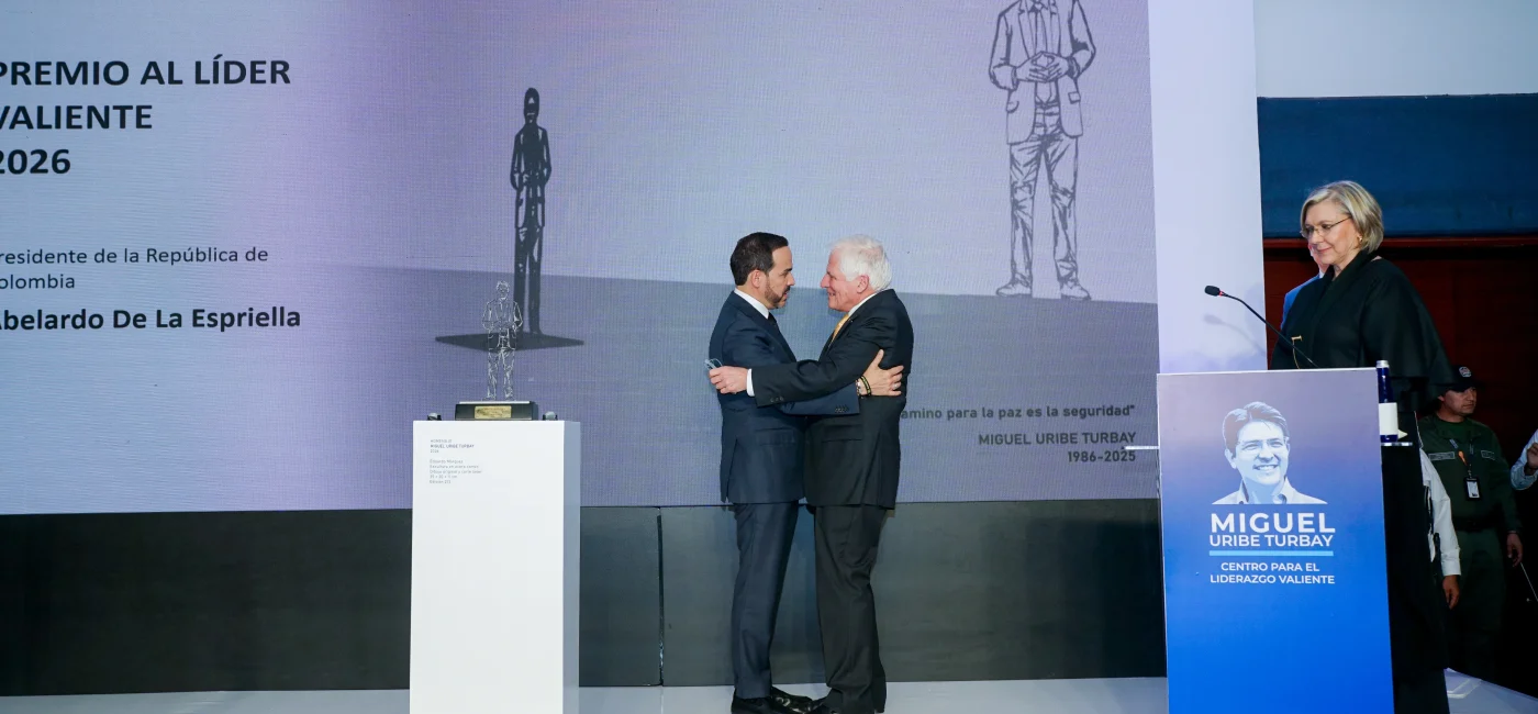 Abelardo de la Espriella recibe un abrazo sobre el escenario tras ser galardonado con el Premio Liderazgo Valiente.