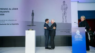 Abelardo de la Espriella recibe un abrazo sobre el escenario tras ser galardonado con el Premio Liderazgo Valiente.
