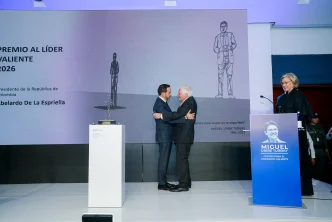Abelardo de la Espriella recibe un abrazo sobre el escenario tras ser galardonado con el Premio Liderazgo Valiente.