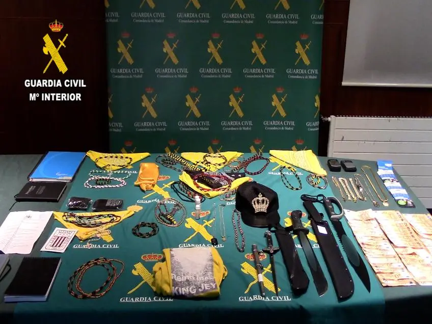 Armas blancas, machetes, collares amarillos y dinero en efectivo incautados por la Guardia Civil a miembros de los Latin Kings.