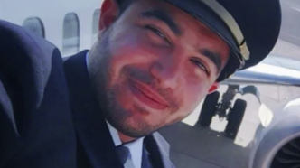 Retrato del copiloto Hammam al-Hammami sonriendo con gorra y uniforme de piloto comercial frente a un avión.