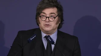 El presidente de Argentina, Javier Milei, hablando desde un atril con gafas de pasta negra y traje oscuro.