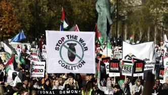 Manifestantes en Londres con pancartas de Stop the War Coalition y banderas palestinas.