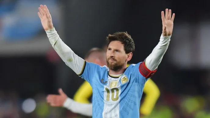 Lionel Messi saludando a la afición con los brazos en alto vistiendo la camiseta de la Selección Argentina.