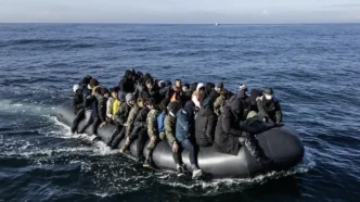 Grupo de migrantes hacinados a bordo de una pequeña embarcación neumática cruzando el mar.