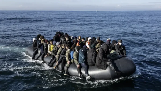 Grupo de migrantes hacinados a bordo de una pequeña embarcación neumática cruzando el mar.