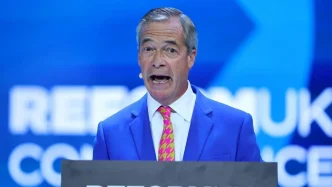 Nigel Farage hablando en un atril azul durante un evento político del Partido Reformista.