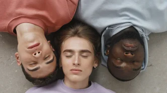 Tres jóvenes de diversas procedencias étnicas acostados juntos con los ojos cerrados.