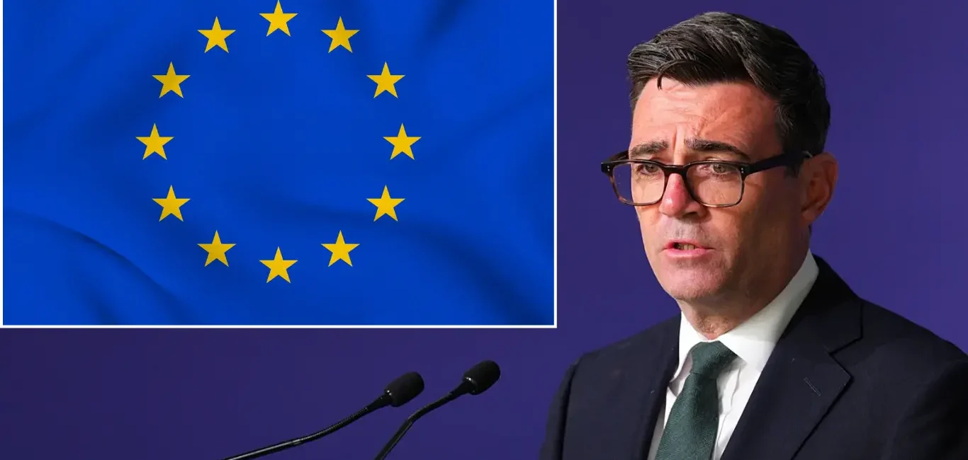 Andy Burnham en el atril con la bandera de la Unión Europea al fondo.