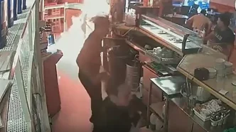 Fotograma de cámara de seguridad que muestra a un hombre rociando combustible sobre la barra de un bar en Los Palacios.