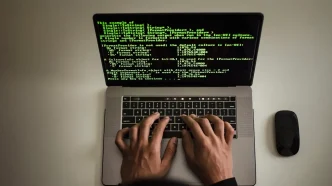Manos de un programador escribiendo código verde sobre la pantalla de un ordenador portátil.