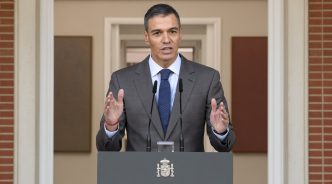 El presidente del Gobierno, Pedro Sánchez, con traje gris y corbata azul, dando una declaración institucional en el atril del Palacio de la Moncloa.