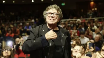 El cantautor argentino Piero sonríe mientras saluda al público durante un concierto.