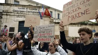 Estudiantes franceses protestan frente al Lycée Georges Clemenceau con carteles manuscritos de reclamo educativo.