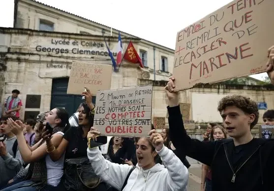 Estudiantes franceses protestan frente al Lycée Georges Clemenceau con carteles manuscritos de reclamo educativo.