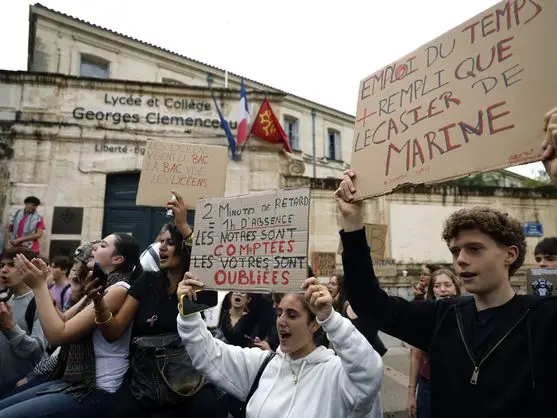 Estudiantes franceses protestan frente al Lycée Georges Clemenceau con carteles manuscritos de reclamo educativo.