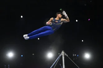 Gimnastas compitiendo con concentración y fuerza en el aparato de gimnasia artística.