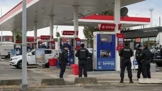 Agentes de policía uniformados custodiando una gasolinera en la periferia de París tras los tiroteos.