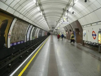 Pasajeros caminando por el andén iluminado de la estación de metro Angel en Londres.