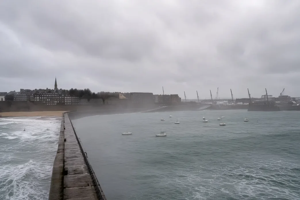 Vista panorámica gris y nublada de una costa marítima azotada por fuertes vientos y olas en el Reino Unido.