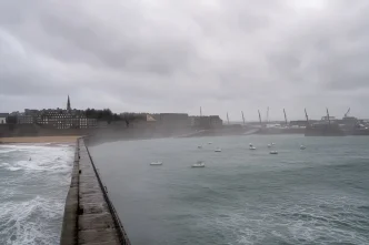 Vista panorámica gris y nublada de una costa marítima azotada por fuertes vientos y olas en el Reino Unido.